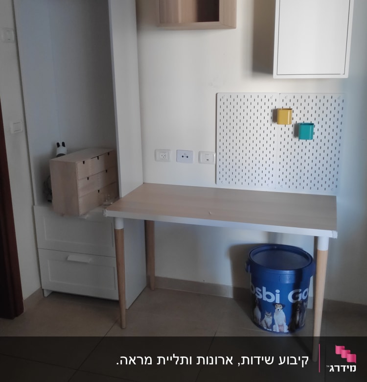 שולחן עבודה עם לוח כלים וקופסאות צבעוניות